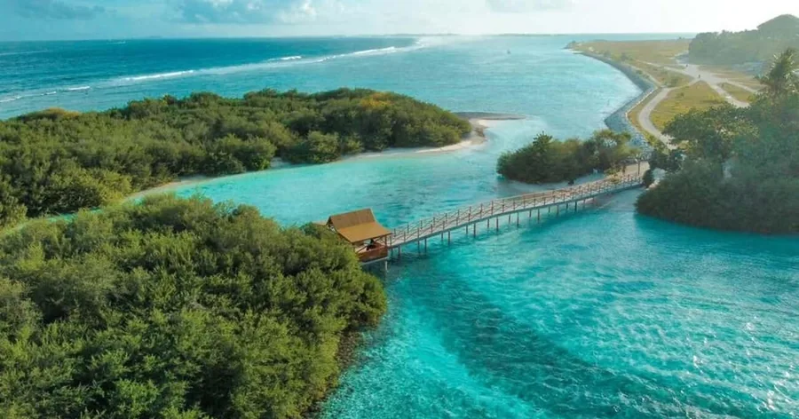 Luftaufnahme grüner Inseln, eines türkisfarbenen Kanals und einer langen Brücke über die Lagune